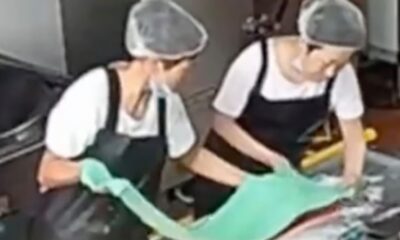 Captura de pantalla de una cámara de seguridad que muestra al personal de cocina añadiendo colorante a la harina. (Weibo)