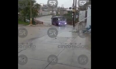 Camión del transporte público “Morados” quedó varado por una inundación en Flor del Bosque, Puebla capital, tras lluvias intensas del 2 de julio.
