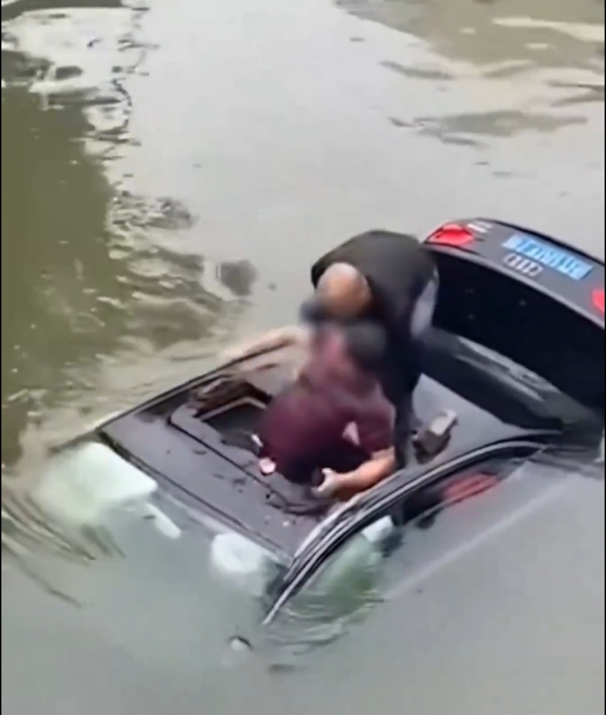 En Taizhou, un hombre rompió la ventanilla de un auto hundido con una piedra y rescató a su conductor atrapado en el agua.