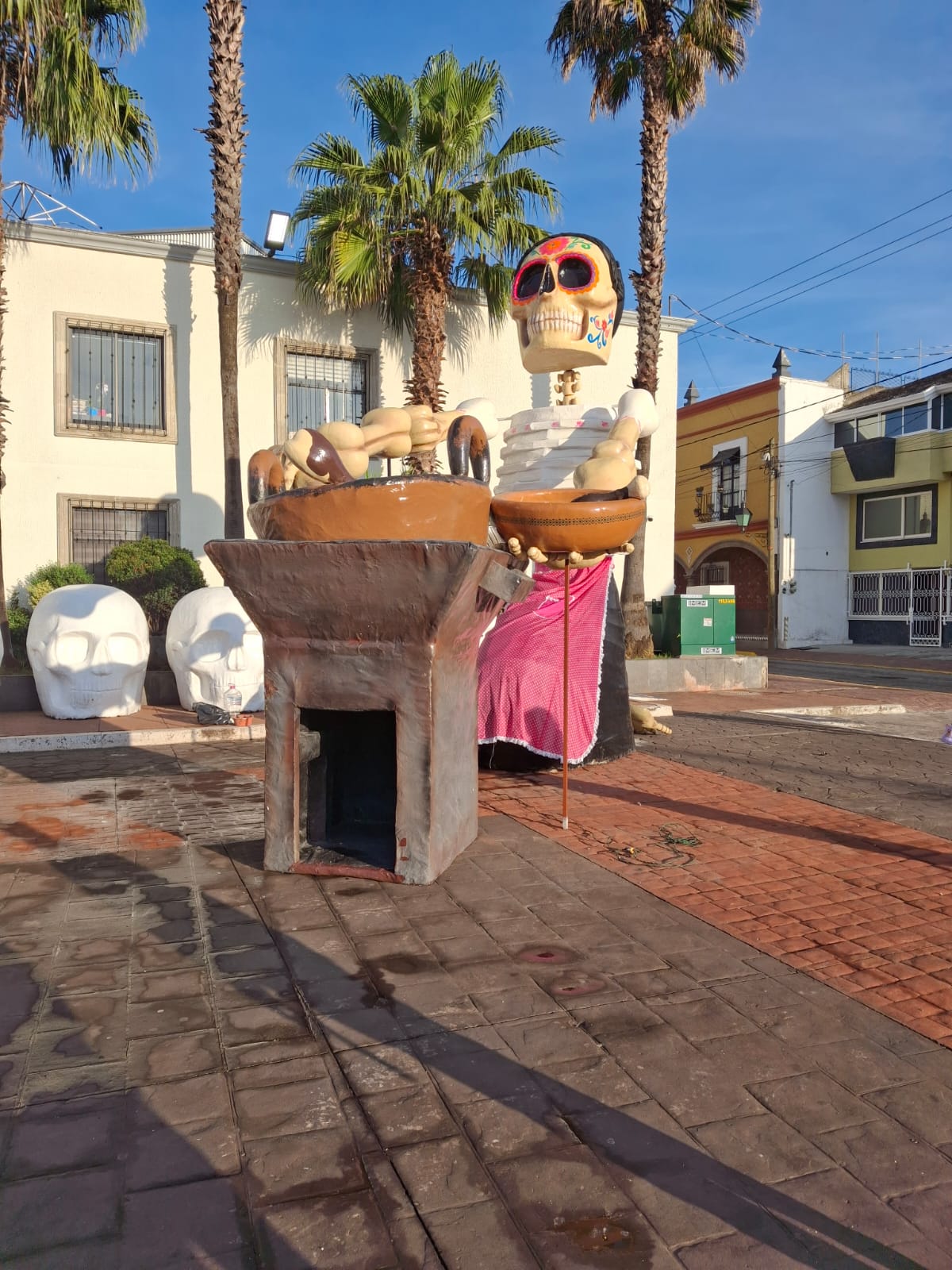 La explanada municipal se llena de tradición con figuras que representan la cultura local y las costumbres del Día de Muertos.